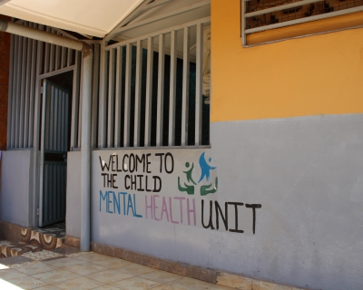Yellow and gray building with the words &quot;welcome to the mental health unit&quot; painted on them.