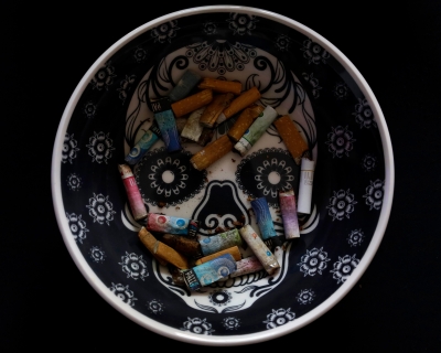 View of cigarette butts on an ashtray with an image of a sugar skull, in Mexico City. 